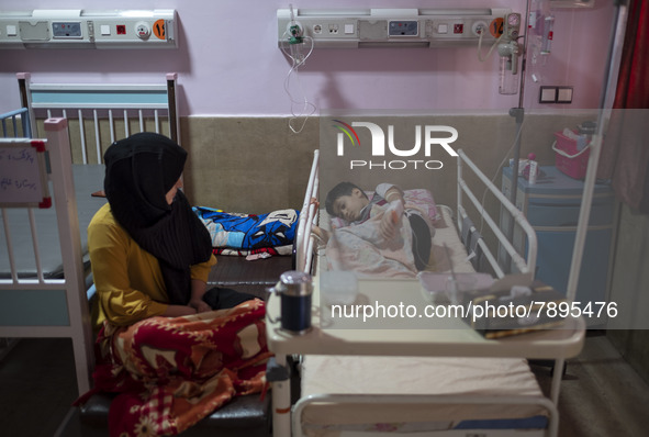 An Iranian mother sits next to her 9-year-old son who is infected by COVID-19, at a COVID-19 ward in a children hospital in the holy city of...