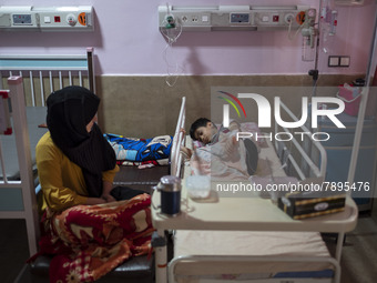 An Iranian mother sits next to her 9-year-old son who is infected by COVID-19, at a COVID-19 ward in a children hospital in the holy city of...