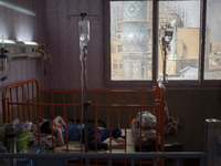 An Iranian 9-year-old boy with autism who is infected by COVID-19 as well, lies on a hospital bed at a new coronavirus disease ward in a chi...