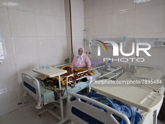 An Iranian elderly woman who is infected by COVID-19 uses oxygen while sitting on a hospital bed at a COVID-19 ward in a hospital in the hol...