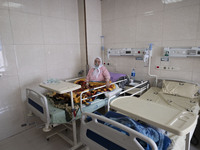 An Iranian elderly woman who is infected by COVID-19 uses oxygen while sitting on a hospital bed at a COVID-19 ward in a hospital in the hol...