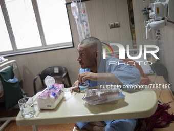 An Iranian man who is infected by COVID-19 looks on as he sits on a hospital bed at a COVID-19 ward in a hospital in the holy city of Qom 14...