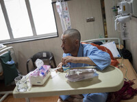 An Iranian man who is infected by COVID-19 looks on as he sits on a hospital bed at a COVID-19 ward in a hospital in the holy city of Qom 14...