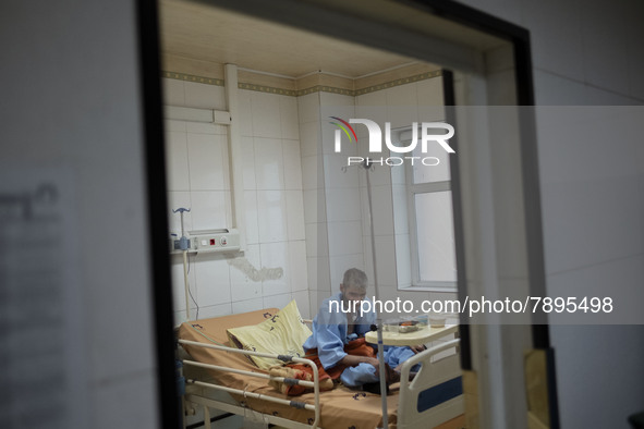 An Iranian elderly man who is infected by COVID-19 sits on a hospital bed at a COVID-19 ward in a hospital in the holy city of Qom 145Km (90...