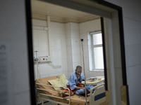 An Iranian elderly man who is infected by COVID-19 sits on a hospital bed at a COVID-19 ward in a hospital in the holy city of Qom 145Km (90...