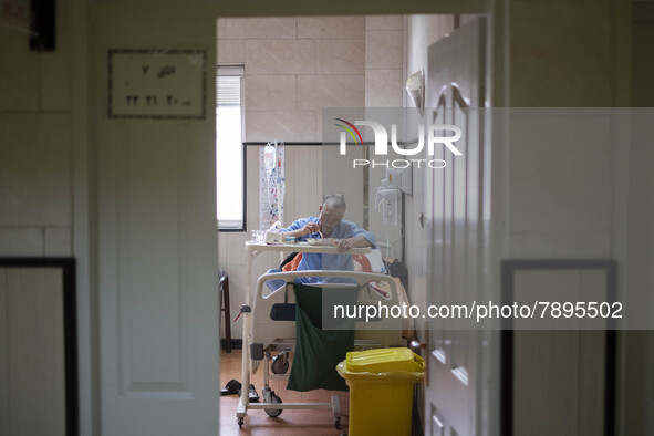 An Iranian man who is infected by COVID-19 eats meal as he sits on a hospital bed at a COVID-19 ward in a hospital in the holy city of Qom 1...