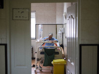 An Iranian man who is infected by COVID-19 eats meal as he sits on a hospital bed at a COVID-19 ward in a hospital in the holy city of Qom 1...