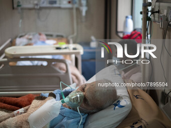 An Iranian elderly man who is infected by COVID-19 uses oxygen as he lies on a hospital bed at a COVID-19 ward in a hospital in the holy cit...