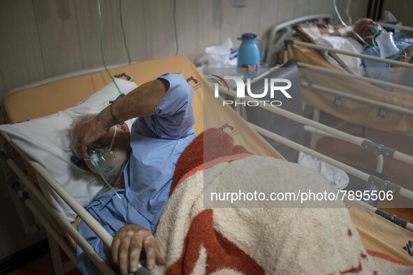 Two Iranian elderly men who are infected by COVID-19 use oxygen as they lie on hospital beds at a COVID-19 ward in a hospital in the holy ci...