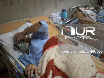 Two Iranian elderly men who are infected by COVID-19 use oxygen as they lie on hospital beds at a COVID-19 ward in a hospital in the holy ci...