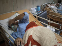 Two Iranian elderly men who are infected by COVID-19 use oxygen as they lie on hospital beds at a COVID-19 ward in a hospital in the holy ci...