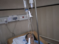 An Iranian man who is infected by COVID-19 lies on a hospital bed at a COVID-19 ward in a hospital in the holy city of Qom 145Km (90 miles)...