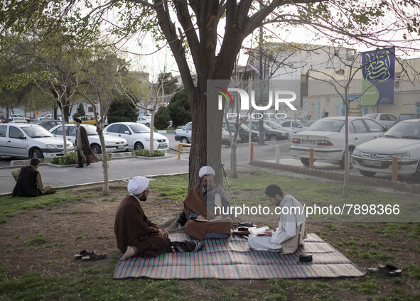 Clerics study religious lessons while sitting on a street-side in the holy city of Qom 145Km (90 miles) south of Tehran on March 10, 2022. 