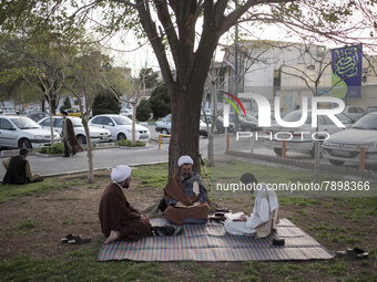 Clerics study religious lessons while sitting on a street-side in the holy city of Qom 145Km (90 miles) south of Tehran on March 10, 2022. (