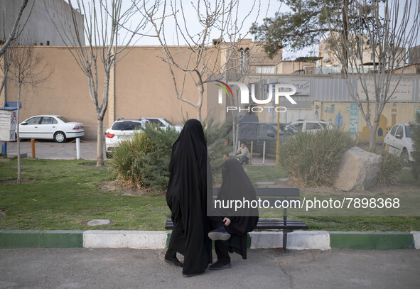 Two veiled women on a street-side in the holy city of Qom 145Km (90 miles) south of Tehran on March 10, 2022. 