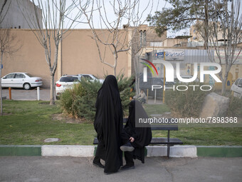 Two veiled women on a street-side in the holy city of Qom 145Km (90 miles) south of Tehran on March 10, 2022. (