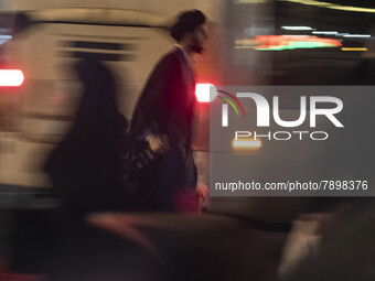 An Iranian cleric walks along an avenue in the holy city of Qom 145Km (90 miles) south of Tehran at night on March 10, 2022. (