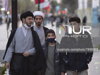 Two clerics and youths walk along a street in the holy city of Qom 145Km (90 miles) south of Tehran on March 10, 2022. (