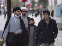 Two clerics and youths walk along a street in the holy city of Qom 145Km (90 miles) south of Tehran on March 10, 2022. (