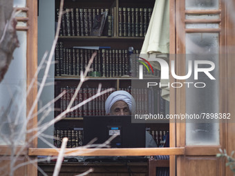 An Iranian cleric sits behind a computer display at a room in the house of Ayatollah Ruhollah Khomeini, founder and first spiritual leader o...