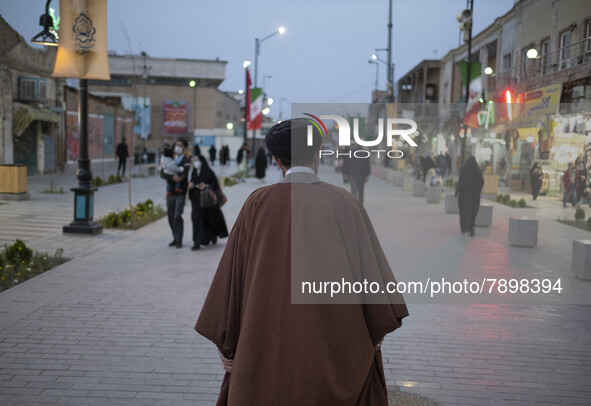 A cleric walks along a street in the holy city of Qom 145Km (90 miles) south of Tehran at sunset on March 10, 2022. 