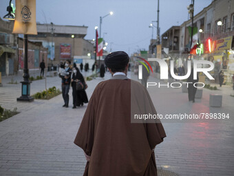 A cleric walks along a street in the holy city of Qom 145Km (90 miles) south of Tehran at sunset on March 10, 2022. (