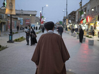 A cleric walks along a street in the holy city of Qom 145Km (90 miles) south of Tehran at sunset on March 10, 2022. (