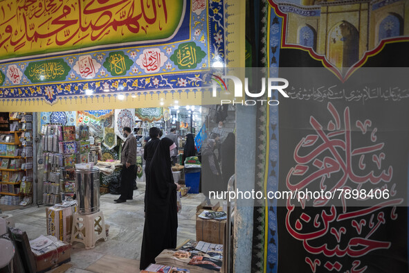 An Iranian veiled woman stands next to religious flag while shopping in a religious shopping center in the holy city of Qom 145Km (90 miles)...