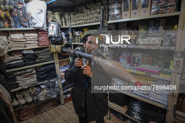 An Iranian man poses for a photograph while holding a plastic RPG-7 at a shop in a religious shopping center in the holy city of Qom 145Km (...