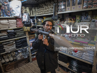 An Iranian man poses for a photograph while holding a plastic RPG-7 at a shop in a religious shopping center in the holy city of Qom 145Km (...