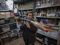 An Iranian man poses for a photograph while holding a plastic RPG-7 at a shop in a religious shopping center in the holy city of Qom 145Km (...