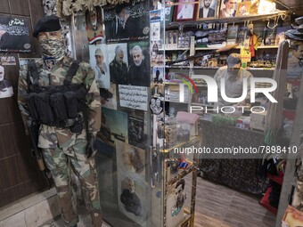 A mannequin decorated with an Islamic Revolutionary Guard Corps (IRGC) military uniform next to the portraits of the former commander of IRG...