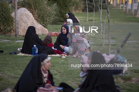 Iranian women sit on a street-side in the holy city of Qom 145Km (90 miles) south of Tehran on March 10, 2022. 