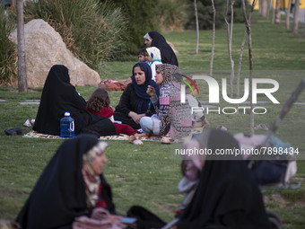 Iranian women sit on a street-side in the holy city of Qom 145Km (90 miles) south of Tehran on March 10, 2022. (