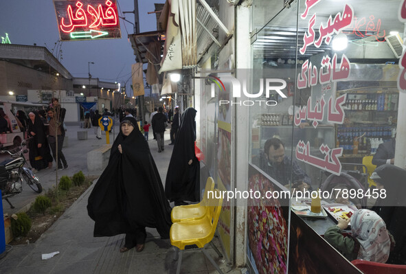 A family sit at a small fast-food restaurant near a holy shrine in the holy city of Qom 145Km (90 miles) south of Tehran on March 10, 2022. 