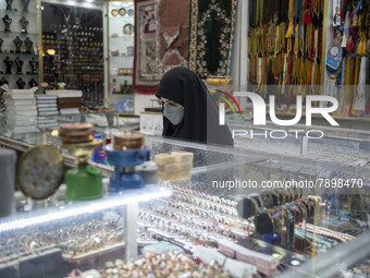 A veiled woman wearing a protective face mask stands at a jewelry shop near a holy shrine in the holy city of Qom 145Km (90 miles) south of...