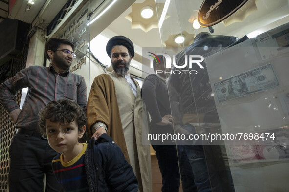 An Iranian cleric and his young son walk out of an exchange shop near a holy shrine in the holy city of Qom 145Km (90 miles) south of Tehran...