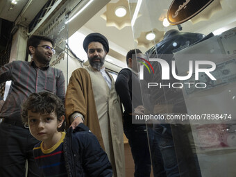 An Iranian cleric and his young son walk out of an exchange shop near a holy shrine in the holy city of Qom 145Km (90 miles) south of Tehran...