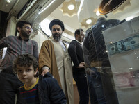 An Iranian cleric and his young son walk out of an exchange shop near a holy shrine in the holy city of Qom 145Km (90 miles) south of Tehran...