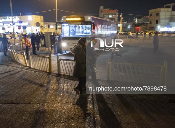 A couple walk along an avenue near a holy shrine in the holy city of Qom 145Km (90 miles) south of Tehran at night on March 10, 2022. 