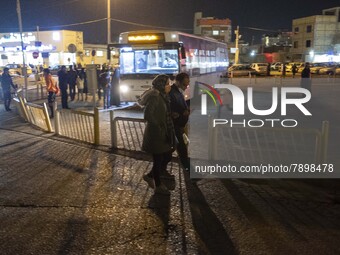 A couple walk along an avenue near a holy shrine in the holy city of Qom 145Km (90 miles) south of Tehran at night on March 10, 2022. (