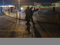 A couple walk along an avenue near a holy shrine in the holy city of Qom 145Km (90 miles) south of Tehran at night on March 10, 2022. (