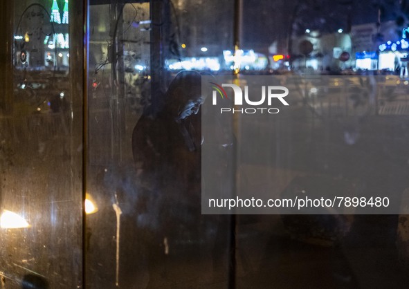 An Iranian man uses his smartphone while standing at a bus stand near a holy shrine in the holy city of Qom 145Km (90 miles) south of Tehran...