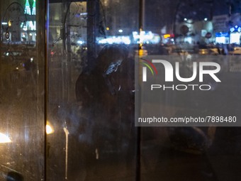 An Iranian man uses his smartphone while standing at a bus stand near a holy shrine in the holy city of Qom 145Km (90 miles) south of Tehran...