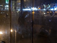 An Iranian man uses his smartphone while standing at a bus stand near a holy shrine in the holy city of Qom 145Km (90 miles) south of Tehran...