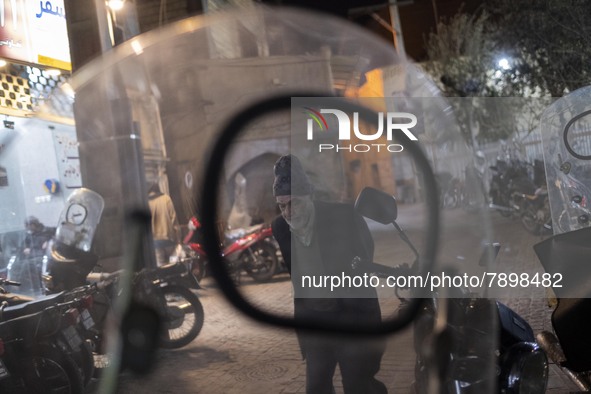 An Iranian elderly man walks along an alley in the holy city of Qom 145 Km (90 miles) south of Tehran at night on March 10, 2022. 