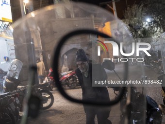 An Iranian elderly man walks along an alley in the holy city of Qom 145 Km (90 miles) south of Tehran at night on March 10, 2022. (