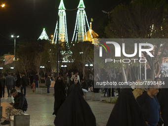 People walk along a pedestrian street near a holy shrine in the holy city of Qom 145Km (90 miles) south of Tehran at night on March 10, 2022...