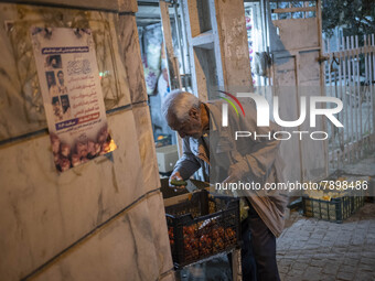 An Iranian elderly man collects cucumber while shopping in the holy city of Qom 145Km (90 miles) south of Tehran at night on March 10, 2022....