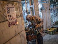 An Iranian elderly man collects cucumber while shopping in the holy city of Qom 145Km (90 miles) south of Tehran at night on March 10, 2022....